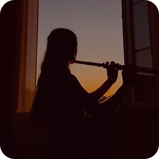 Silhouette jouant de la flûte devant une fenêtre au coucher du soleil